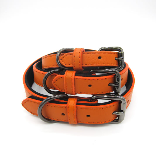 Stacked burnt orange leather collars in small, medium, and large