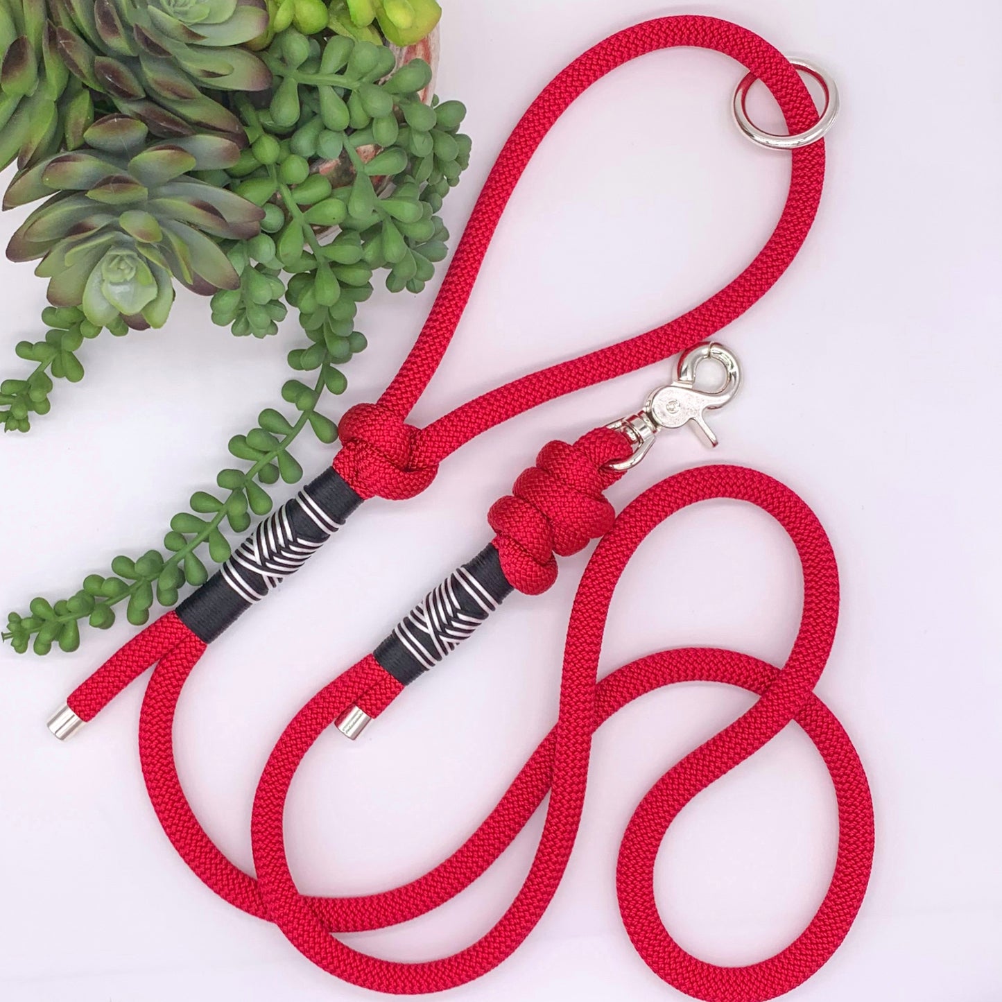 Red PPM rope leash with black and white accent thread in a chevron pattern and silver hardware. 